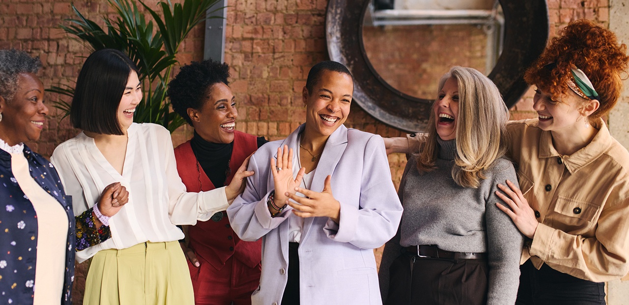 International Women's Day portrait of cheerful multi ethnic mixed age range businesswomen celebrating