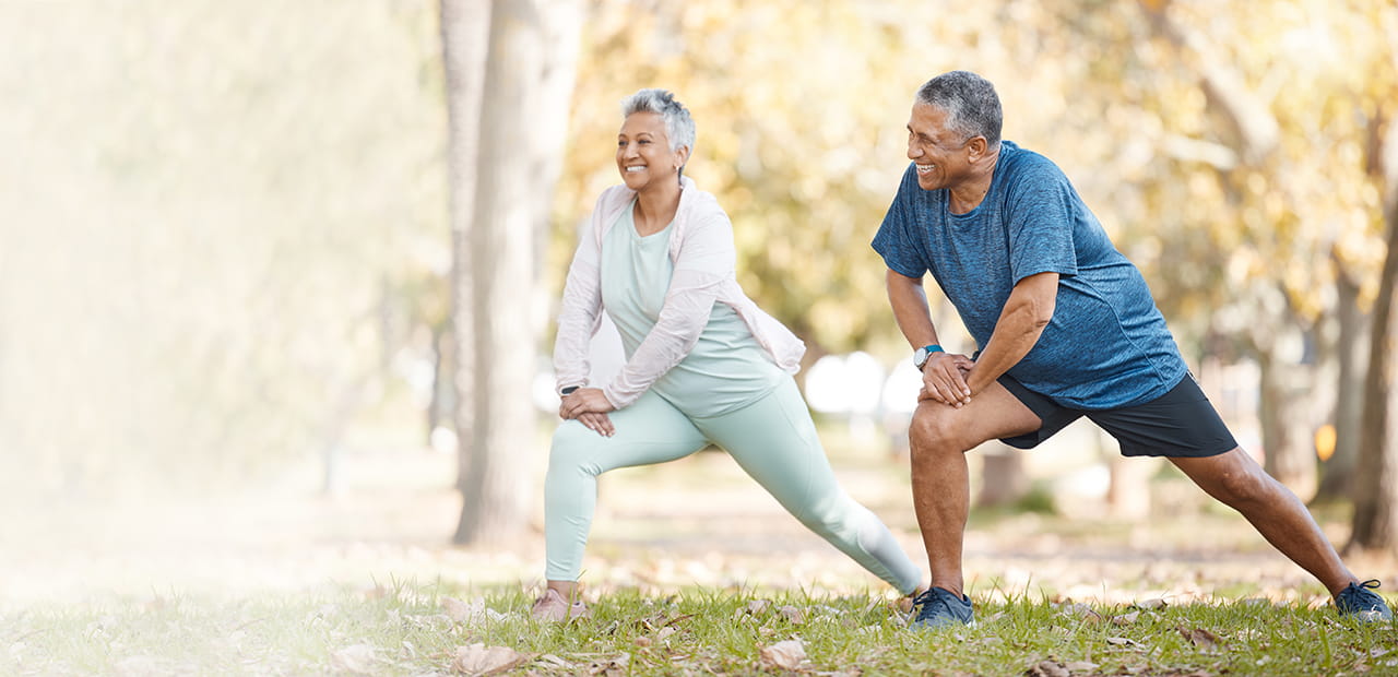 Senior couple stretching in the park