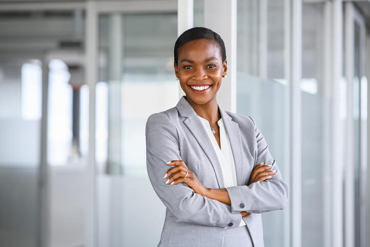 Smiling african american business woman standing in new office