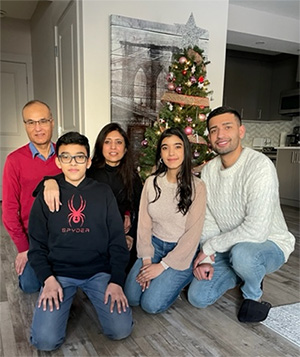 Five people crouched in front of a tree.