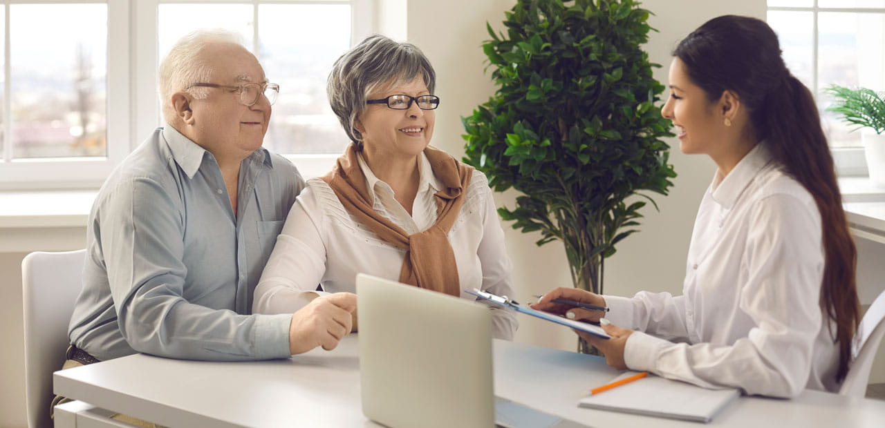 A happy senior couple in a meeting with their financial advisor.