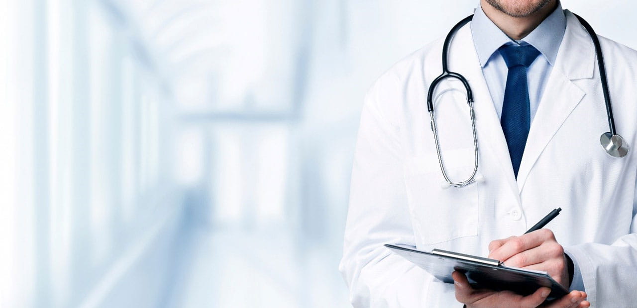 Close up of a doctor writing on a clipboard.