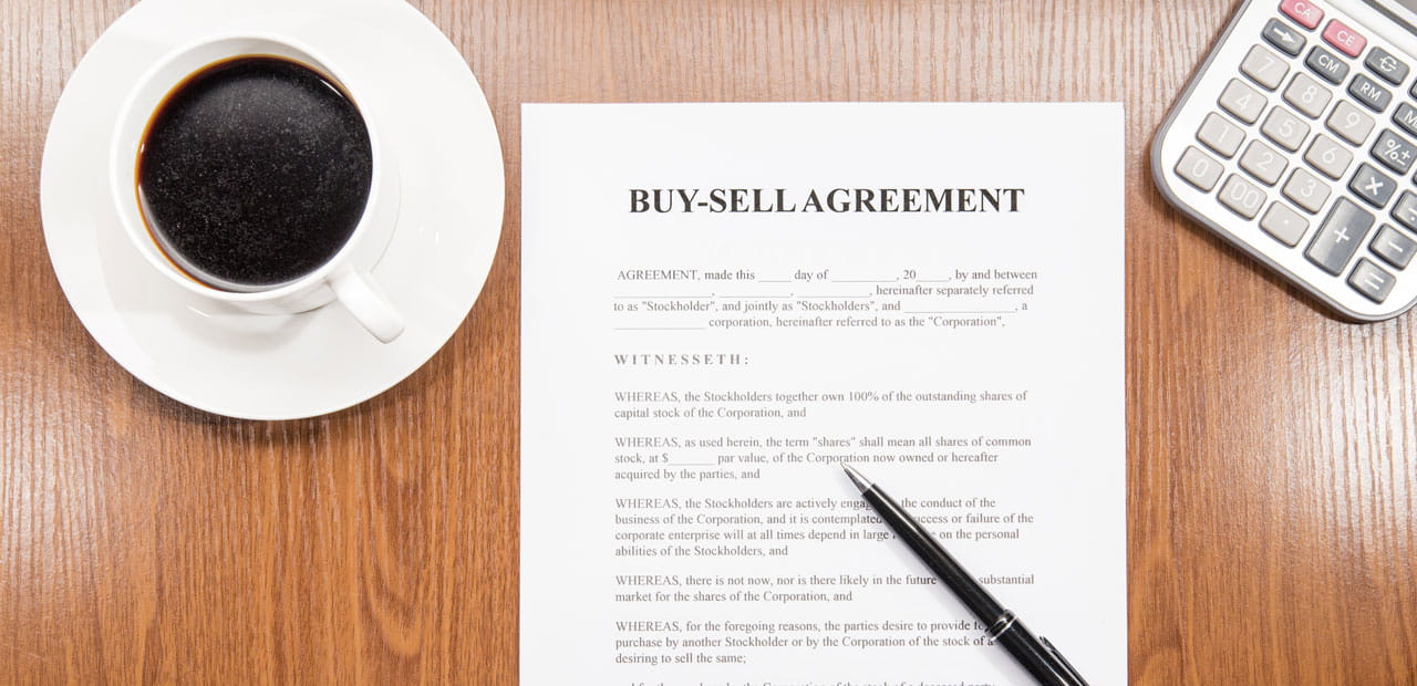 Image of a "Buy-Sell Agreement" document on a table.