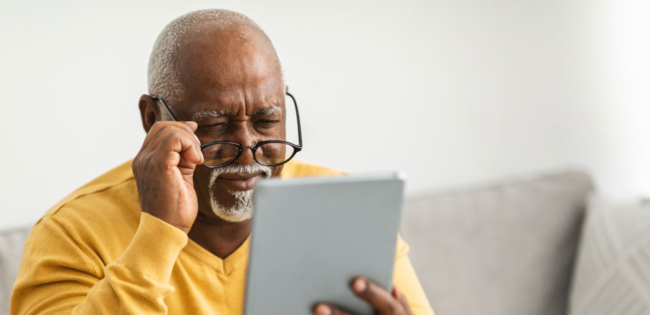 A senior citizen looking at his tablet.