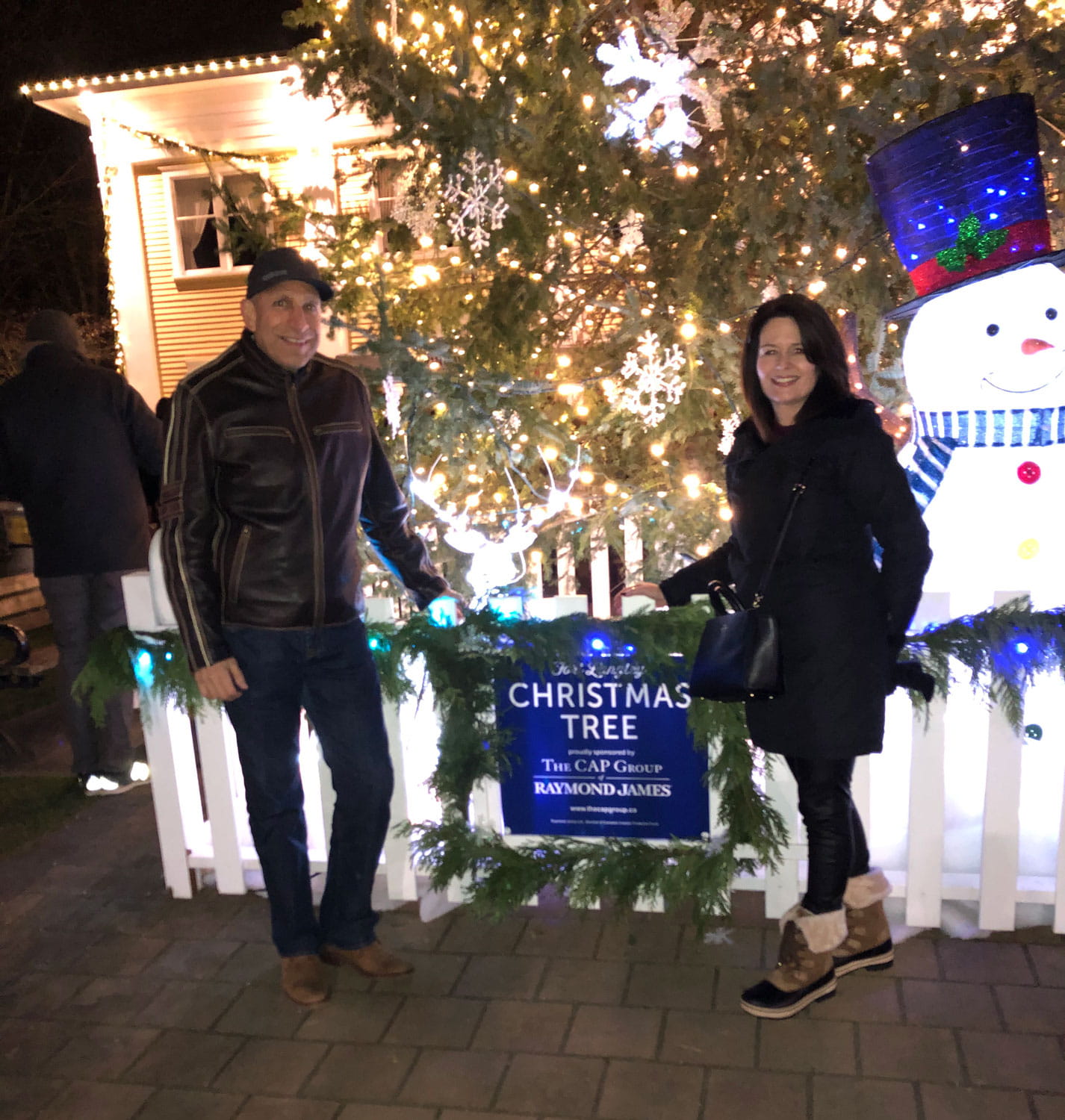 Two people in front of a Christmas tree