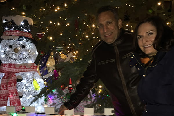 Franco and wife in front of lit snowman and christmas tree